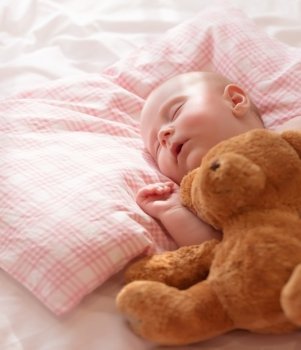 Little baby asleep with plush bear toy, newborn girl napping in the bed at home, child care, closed eyes, healthy lifestyle, happy childhood concept