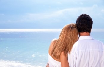 
Rear view of young couple hugging on the beach, honeymoon on Maldives, enjoying wonderful seaview, love concept
