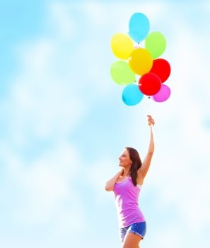 Beautiful young woman holding in hand many colorful balloons on blue sky background, summer time holiday, fun concept
