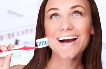 Closeup portrait of beautiful woman clean teeth in the bathroom at home, looking up, perfect smile, dental treatment, refreshment concept
