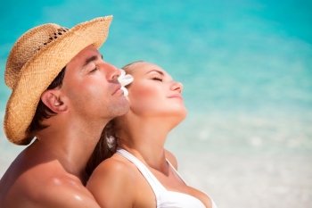 
Closeup portrait of beautiful young lovers with closed eyes enjoying sunny day on the beach, romantic summer vacation, love and togetherness concept