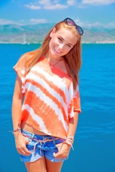 Portrait of cute teen girl standing on blue sea background, having fun on the beach, summer vacation and holidays concept