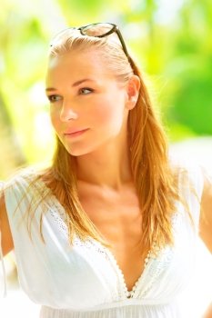 Woman enjoying tropical vacation, beautiful female face over green blur background, model close-up portrait, relaxing holidays on Maldives island, summer travel concept