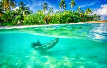 Active female swimming under water, enjoying beautiful sea nature, luxury beach resort on tropical island, summer adventure and journey concept