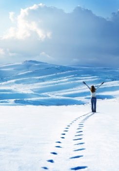 Happy woman jumping at winter mountains, active female enjoying nature, girl playing in the snow, teen having fun outdoor, healthy lifestyle and wintertime holidays vacation concept