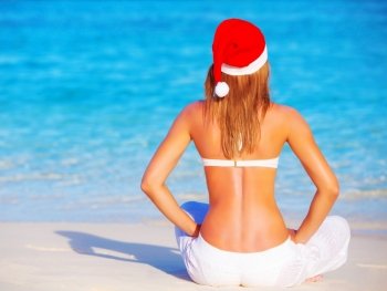 Blond woman celebrating New Year holidays on Maldive islands, enjoying exotic nature, sitting on the beach, luxury vacation concept