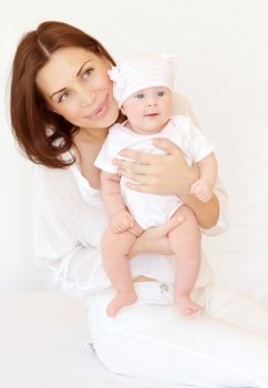 Portrait of pretty female carry cute baby, at home, healthy toddler, happy childhood, love and new life concept