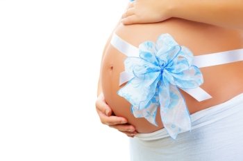 Closeup on belly of expectant woman with cute blue ribbon bow isolated on white background, it's a boy, young family, new life concept