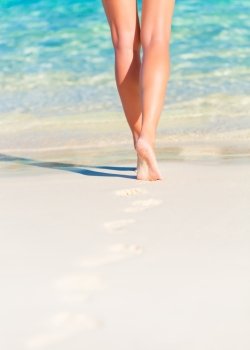 Closeup photo of sexy woman legs, body part, slim female walking on the beach, carefree lifestyle, summer vacation, relaxation concept