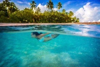 Woman swimming underwater, enjoying transparent sea and tropical nature of island, active lifestyle, summertime adventure, spending vacation in blue lagoon