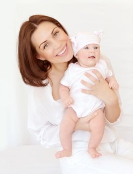 Portrait of attractive brunette mother carry cute baby girl in hands, at home, happy motherhood, young family, love concept
