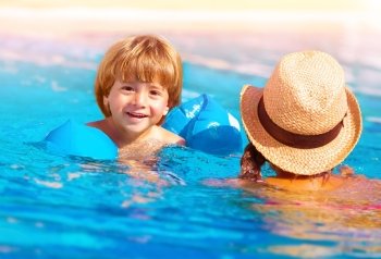 Closeup on cute little boy with mother swimming in the pool, happy family having fun in water, summer vacation, fun and refreshment concept