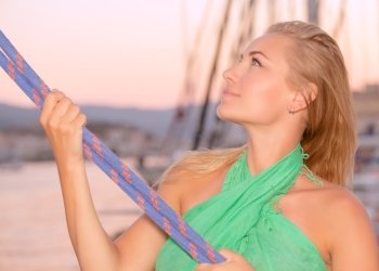 Portrait of a beautiful woman sailing, girl working on sailboat, pulling ropes, active lifestyle, enjoying traveling the world, summer vacation concept