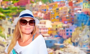 Attractive girl enjoying travel to Europe, standing on wonderful colorful buildings background, famous street in Cinque Terre
