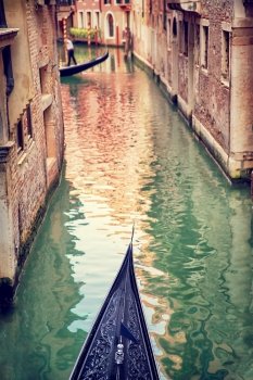 Venice, gondola floating on narrow Venetian street, famous transport in Venetian lagoon, travel and tourism concept