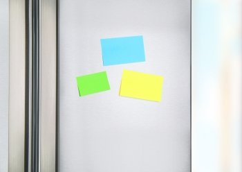 Sticky notes on the fridge, three colorful paper on the door on refrigerator for message, little reminder sheets, communication on the kitchen