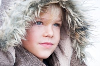 Portrait of a young boy in a fake fur hood