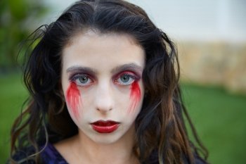 Halloween kid girl custome with bloody makeup on backyard turf