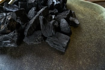 Charcoal for grill on a ceramic plate texture