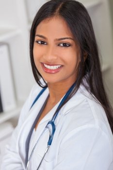 An Indian Asian female medical doctor in a hospital office happy and smiling with stethoscope
