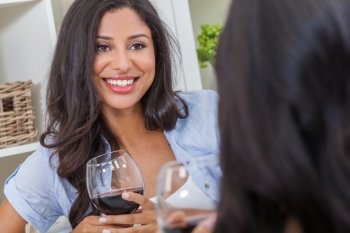 Beautiful Hispanic Latina woman with perfect teeth drinking wine at home with a female friend