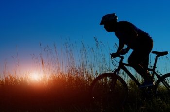 Male cyclist driving outdoors sunset time