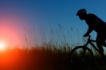 Male cyclist driving outdoors sunset time