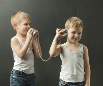 Cute little siblings talking on the toy phone
