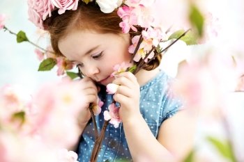 Cute little girl among fresh flowers