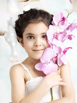 Little brunette girl holding a colorful flower