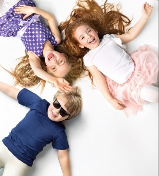 Portrait of little siblings lying on a white background 