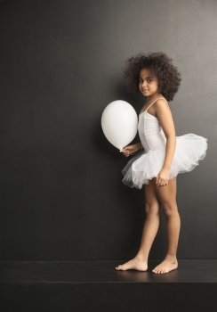 Conceptual picture of a little ballet dancer with a white ballon
