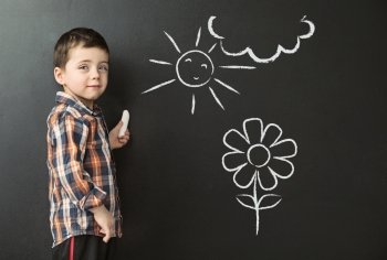 Little boy drawing on the blackboard