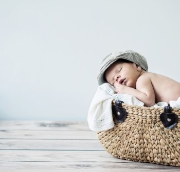 Cute tot sleeping in a wicker basket