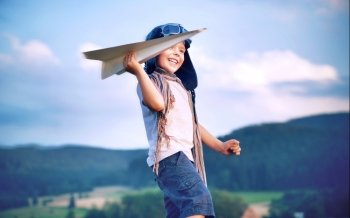 Cheerful little boy toy paper plane