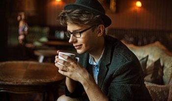 Glad elegant guy drinking a coffee