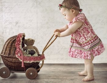 Little cute girl playing the toy carriage