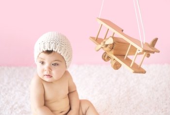 Cute toddler playing with a wooden plane