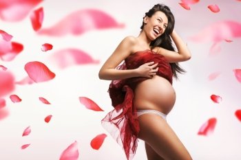 Pretty, delicate, pregnant woman - red petals in the background
