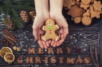 Woman hands keep ginger cookies. Woman hands keep ginger cookies for new years and christmas on wooden background.