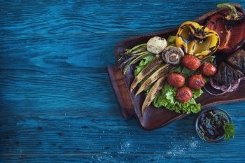 Grilled vegetable at plate. Grilled vegetable on a blue wooden background