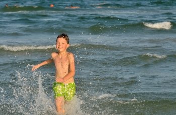 boy running through the waves at the beach