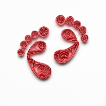 Creative concept photo of quilling feet made of paper on white background.