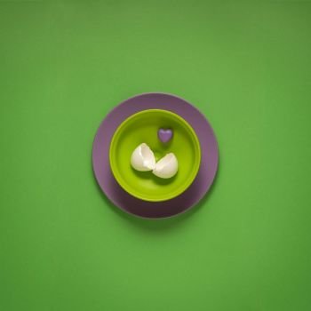 Creative concept photo of painted plates on green background.