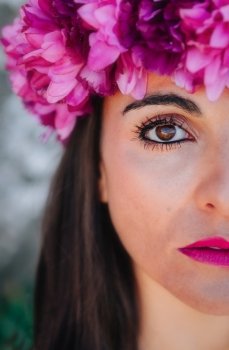 Beautiful Young Woman with Pink Flowers. Long Brunette Hair and Fashion Makeup