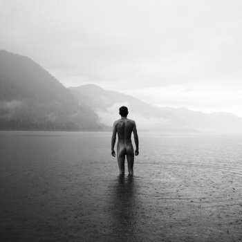 Picturesque landscape. Young naked man in lake