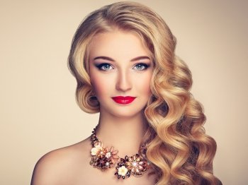 Fashion portrait of young beautiful woman with jewelry and elegant hairstyle. Blonde girl with long wavy hair. Perfect make-up.  Beauty style model