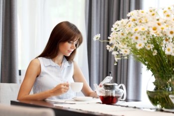 young woman drinking tea. young woman drinking tea and looking at her phone