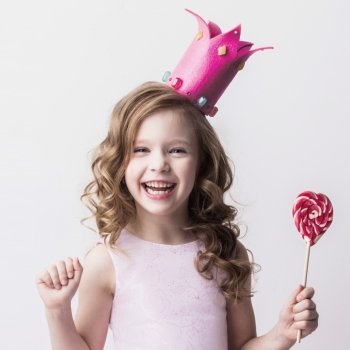 Little candy princess. Beautiful little candy princess girl in crown holding big pink heart lollipop and smiling