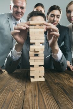 Business team with wood puzzle. Business people team building wood puzzle tower